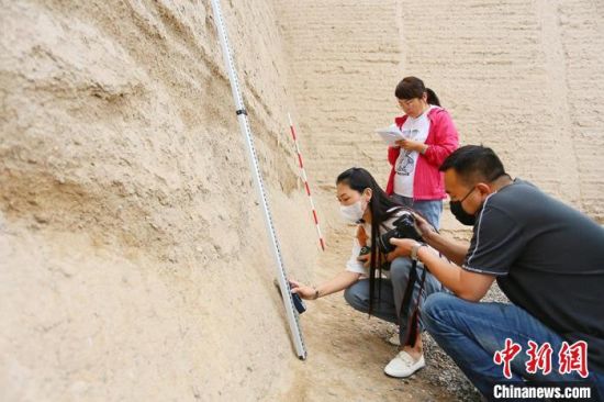 科技保護讓長城價值的真實性和完整性得到有效延續(xù)和傳承。圖為文物工作者正在測量關城的相關數(shù)據(jù)?！「哒?攝