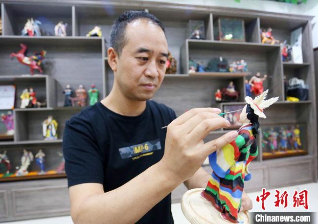 圖為安秋平正在創(chuàng)作代表隴南文縣民俗的《白馬人》作品?！「哒?攝