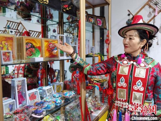 圖為身著民族服飾的隴原巧手展示手工藝品。(資料圖) 徐雪 攝