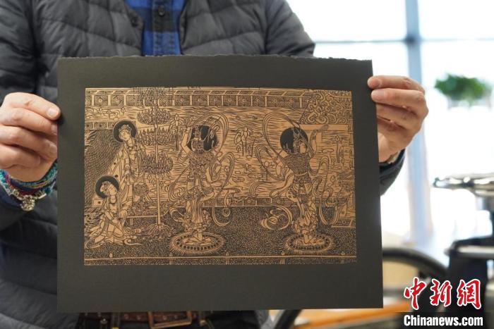 圖為手工書藝人展示敦煌雕版壁畫印刷品?！【琶赖┰?　攝
