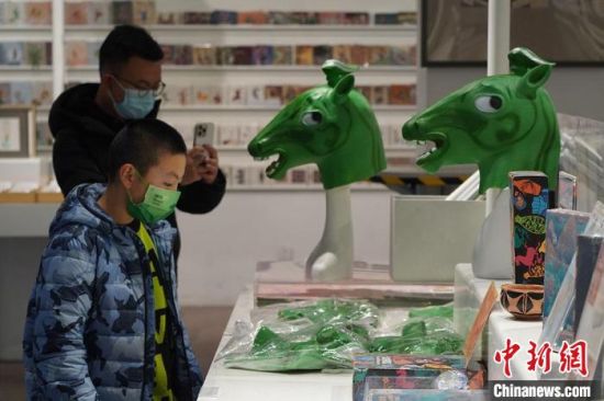 圖為“神馬來了”銅奔馬頭套吸引參觀者駐足。　九美旦增 攝