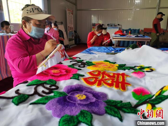 圖為婦女制作青繡?！?zhí)砀?攝