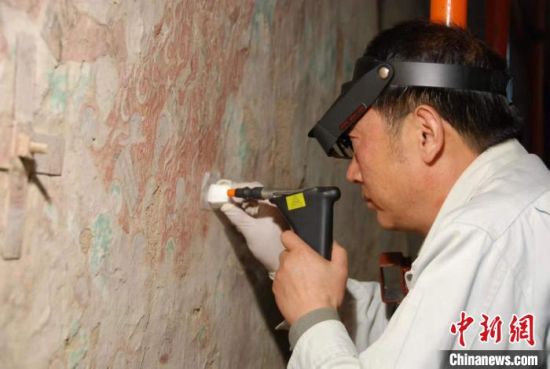 敦煌研究院研究員樊再軒進(jìn)行壁畫修復(fù)。(資料圖)張?jiān)莆?攝