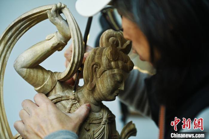 圖為季茂杰進(jìn)行敦煌元素的木雕創(chuàng)作。李亞龍 攝</p>
<p>