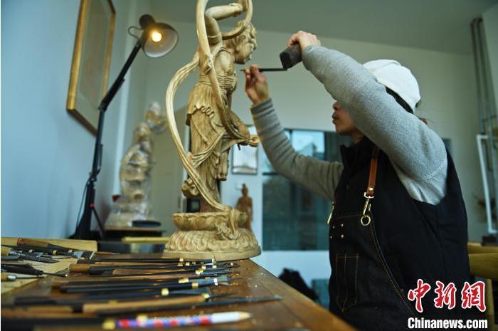 圖為季茂杰進(jìn)行敦煌元素的木雕創(chuàng)作。李亞龍 攝</p>
<p>