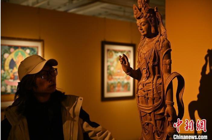 圖為季茂杰觀察自己創(chuàng)作的敦煌木雕。李亞龍 攝</p>
<p>