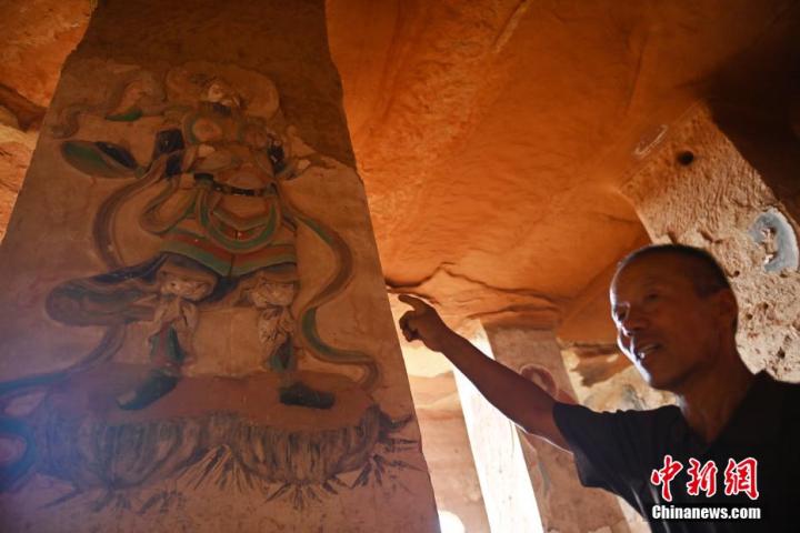 7月15日，甘肅省平?jīng)鍪袥艽h百里石窟長廊羅漢洞石窟內(nèi)，該窟文保員郭建平介紹窟內(nèi)石刻彩繪壁畫。郭建平家中三代人曾自發(fā)保護羅漢洞石窟。羅漢洞石窟遺存40余個窟龕，以北魏至清代風格為主。中新社記者 李亞龍 攝</p>
<p>