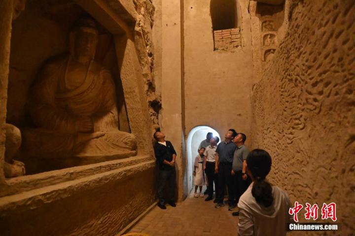 7月15日，游人參觀甘肅省平?jīng)鍪袥艽h百里石窟長廊中的王母宮石窟。百里石窟長廊位于涇川縣境內(nèi)，由512個石窟、5眼窟中石井組成，現(xiàn)存王母宮石窟、鳳凰山石窟、南石窟寺、丈八寺石窟、羅漢洞石窟、太山寺石窟等規(guī)模較大的石窟群，還有數(shù)量眾多的小石窟群。王母宮石窟又名千佛洞，該窟設(shè)計宏大，造像生動，窟內(nèi)擁有造像數(shù)百尊，是較為珍貴的佛教文化歷史遺存。中新社記者 李亞龍 攝</p>
<p>