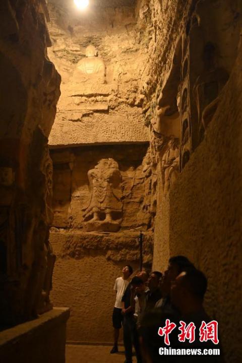 7月15日，游人參觀甘肅省平?jīng)鍪袥艽h百里石窟長廊中的王母宮石窟。百里石窟長廊位于涇川縣境內(nèi)，由512個石窟、5眼窟中石井組成，現(xiàn)存王母宮石窟、鳳凰山石窟、南石窟寺、丈八寺石窟、羅漢洞石窟、太山寺石窟等規(guī)模較大的石窟群，還有數(shù)量眾多的小石窟群。王母宮石窟又名千佛洞，該窟設(shè)計宏大，造像生動，窟內(nèi)擁有造像數(shù)百尊，是較為珍貴的佛教文化遺存。中新社記者 李亞龍 攝</p>
<p>